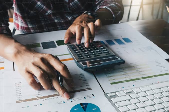 Person analyzing financial documents and calculator